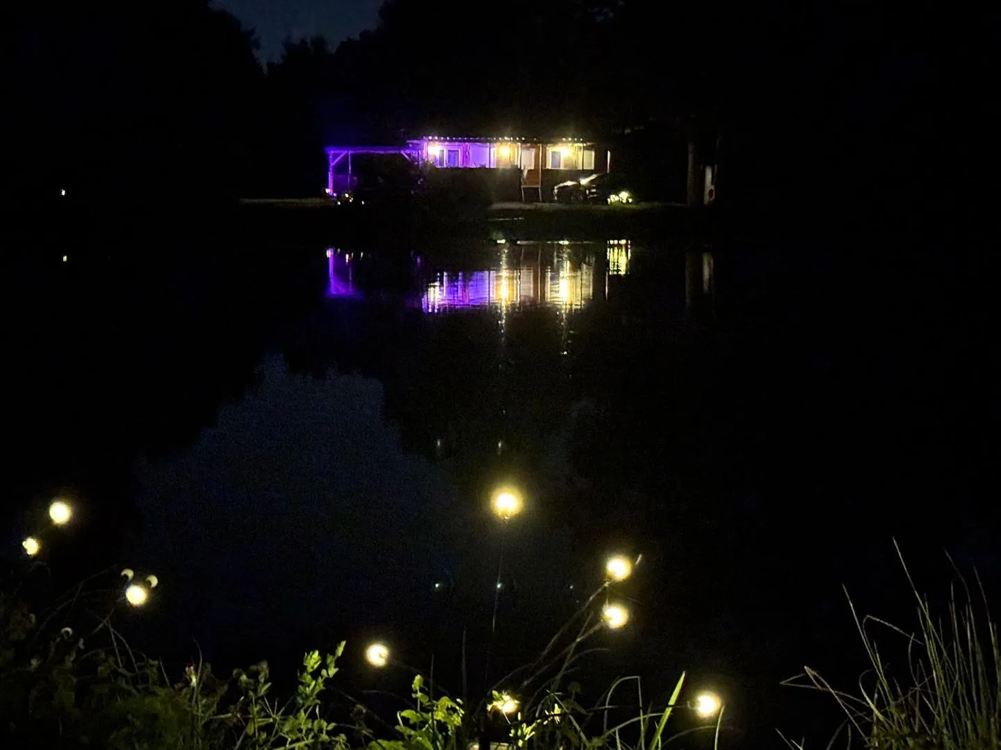 Les lumières du domaine se reflétant dans l’étang la nuit