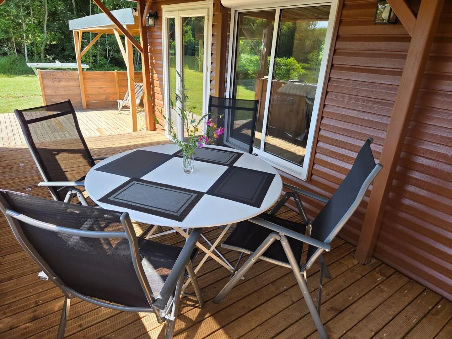 La terrasse couverte avec une table pour quatre personnes